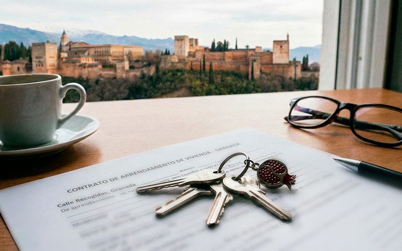 Llaves de un piso en alquiler en Granada junto a un contrato de alquiler